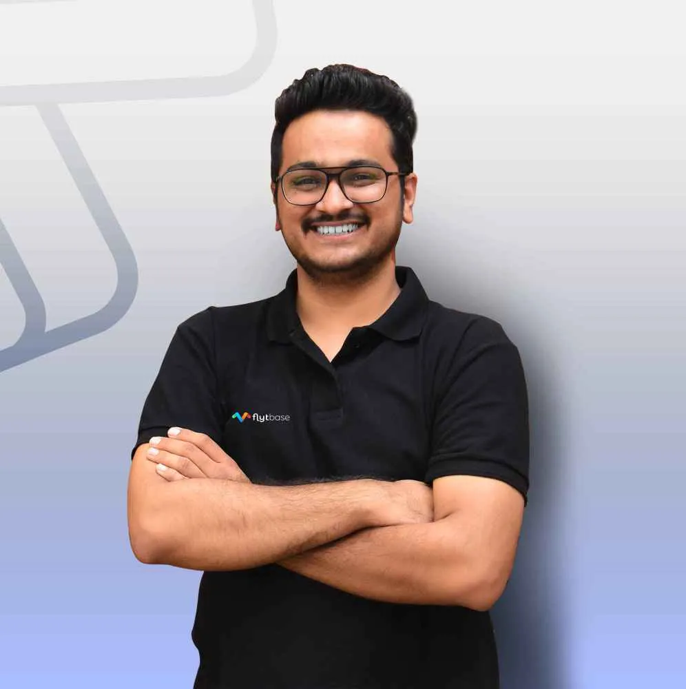 Achal Negi, directeur du développement commercial chez FlytBase, vêtu d'un polo noir et les bras croisés.