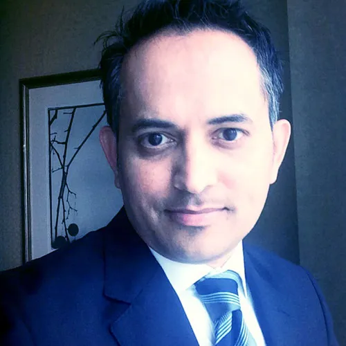 Portrait of Sanjay Kanvinde in a dark suit looking at the camera.