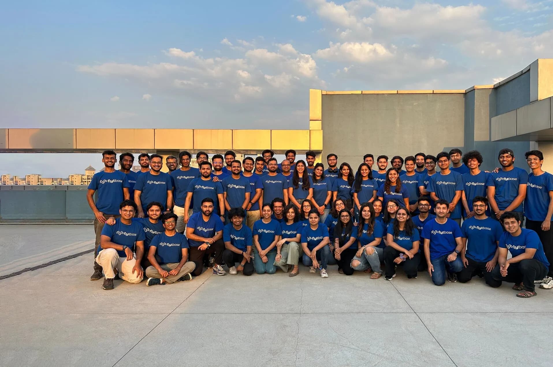 Photo de groupe de l'équipe FlytBase sur un toit au coucher du soleil.